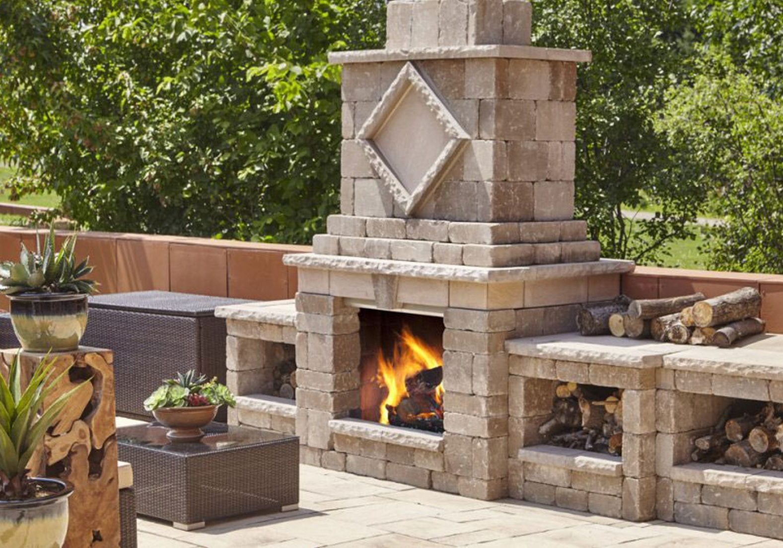 A patio with a fire pit and a fireplace.