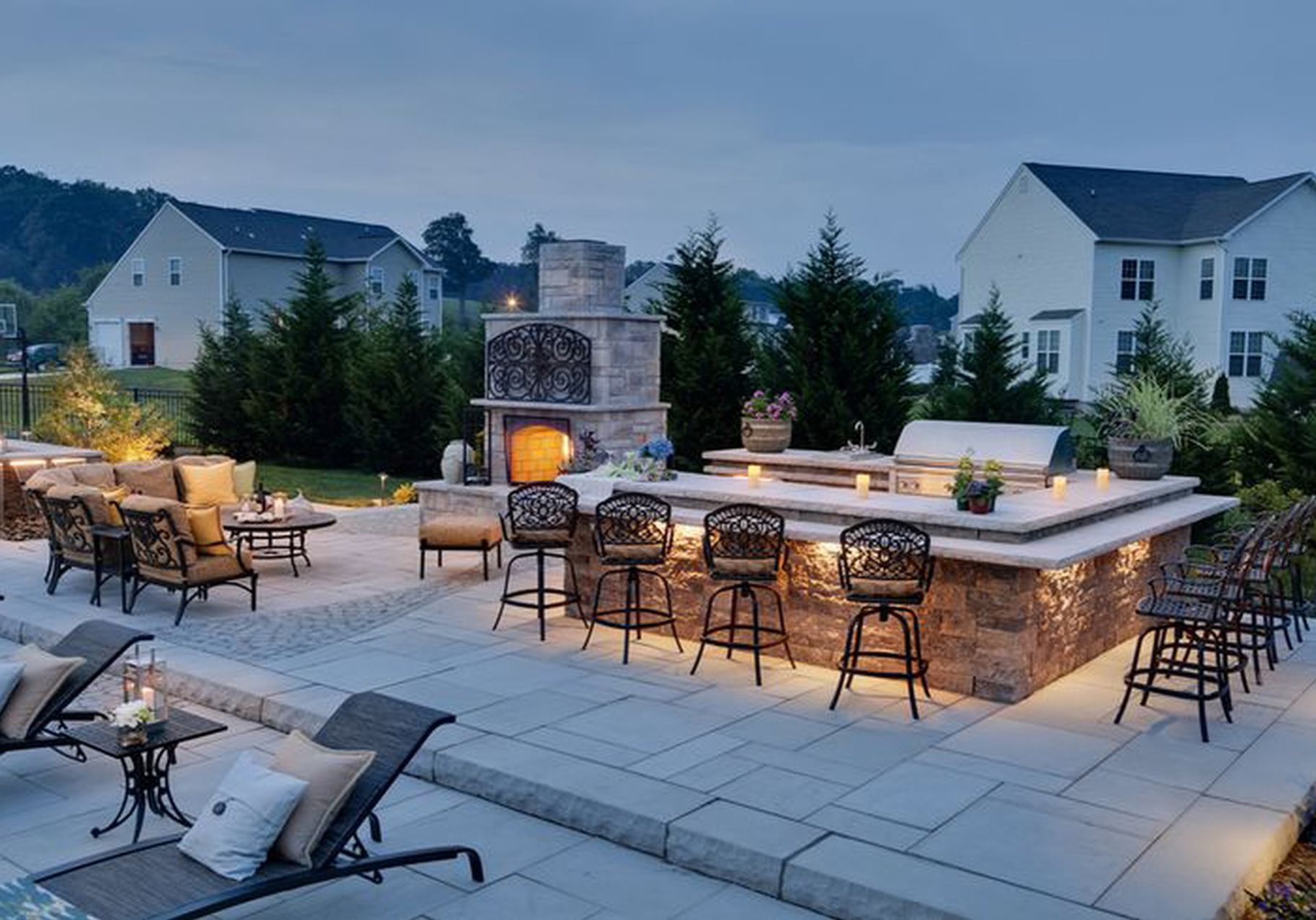 An outdoor kitchen with a fireplace and seating area.