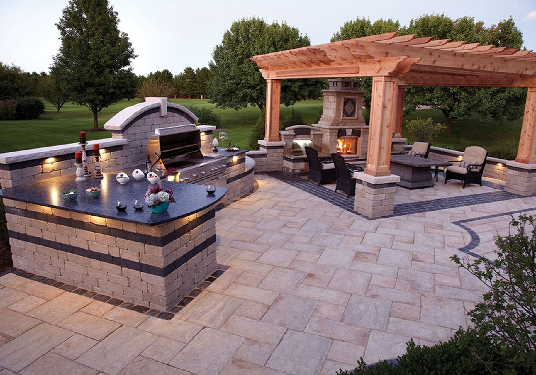 A patio with an outdoor kitchen and fireplace.