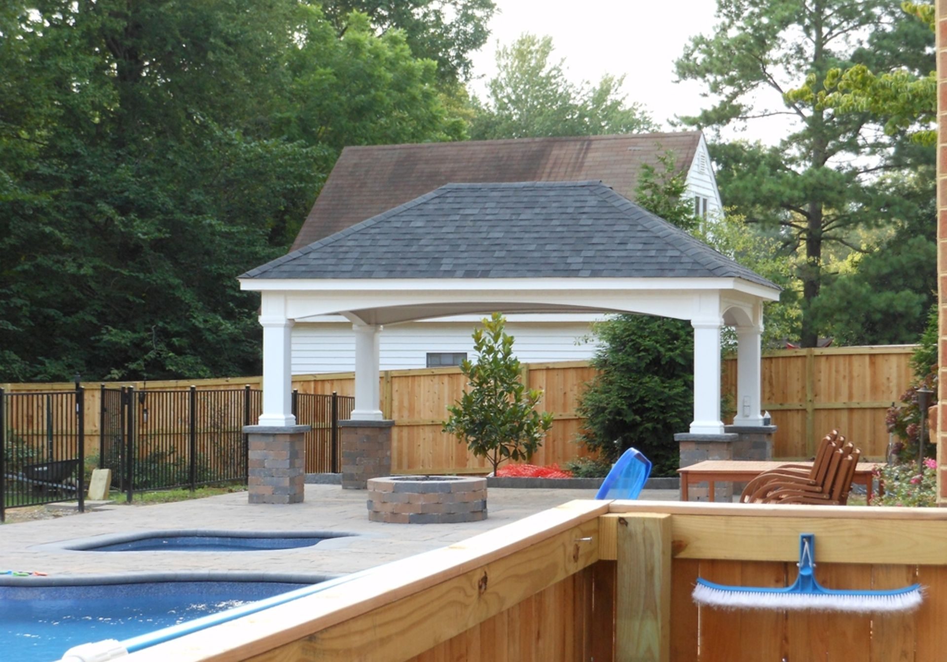 A backyard with a gazebo and a pool.
