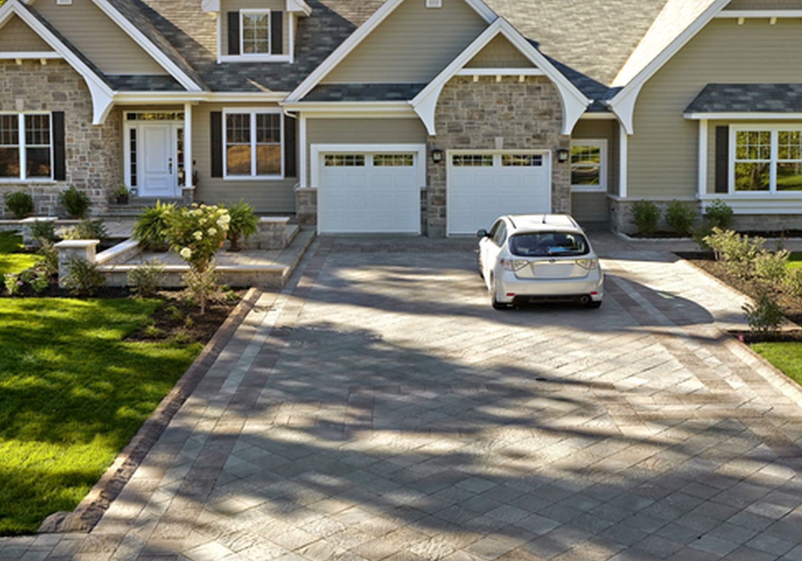 A driveway with a car parked in front of it.