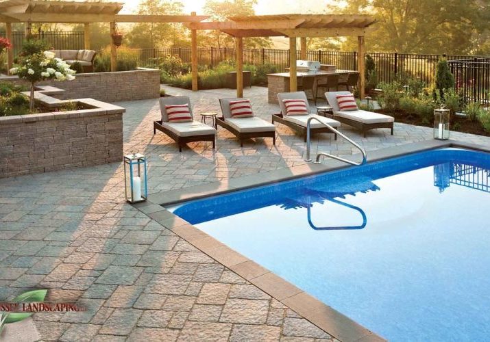 A patio with a swimming pool and lounge chairs.